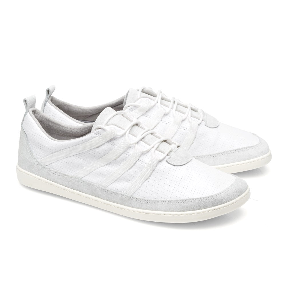 Wir präsentieren den SPARQ Low White von ZAQQ: ein Paar minimalistischer weißer Sneaker mit grauen Akzenten an der Ferse und den Schnürsenkeln. Diese Schuhe bieten hervorragenden Tragekomfort mit einer flachen Sohle und einer perforierten Textur auf der Oberfläche.