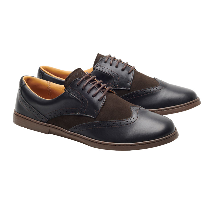 Die von ZAQQ gefertigten BRIQ Brogue Tonka sind elegante Herrenschuhe in Schwarz und Braun mit Brogue-Details, Schnürsenkeln und einer Holzsohle. Diese Schuhe sind abgewinkelt, um ihr stilvolles Design und ihre Handwerkskunst hervorzuheben, was sie zu einer tadellosen Wahl für einen anspruchsvollen Businessschuh macht.