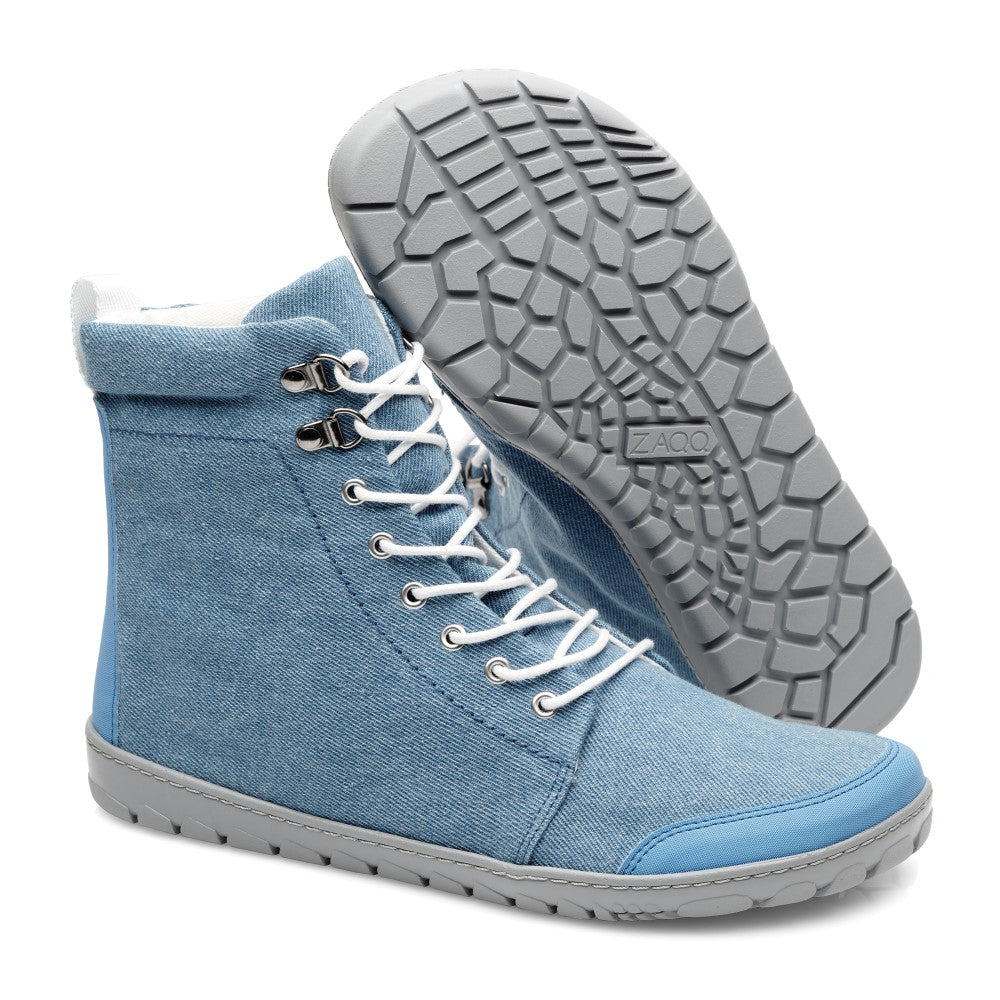 Wir präsentieren die QICE Light Jeans High-Top-Sneaker von ZAQQ, gestaltet aus hellblauem Jeansstoff, mit weißen Schnürsenkeln und Metallösen. Diese Schuhe im Schnürboot-Stil haben eine graue strukturierte Gummisohle und sind mit einer blauen Zehenkappe und Ferse akzentuiert. Die elegante Prägung der Marke ziert die Sohle und verleiht zusätzlichen Stil.