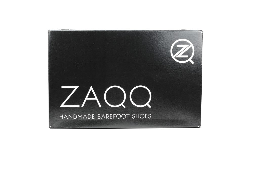 Ein minimalistischer schwarzer Schuhkarton mit dem weißen „ZAQQ“-Logo und dem Schriftzug „Handmade Barefoot Shoes“, begleitet von einer Kautschuksohle. Das stilisierte Z-Logo, das die Business-Barfußschuh-Expertise von ZAQQ hervorhebt, ist prominent in der oberen rechten Ecke platziert.