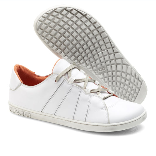 Wir präsentieren die QQQ Low White Sneakers von ZAQQ, ein elegantes Paar aus hochwertigem Nappaleder. Diese Freizeitschuhe haben graue Schnürsenkel und ein leuchtend orangefarbenes Innenleben. Das Design umfasst aufwendige Seitennähte, wobei ein Schuh aufrecht steht und der andere geneigt ist, um die Sohle mit Waffelmuster zu zeigen. Der Markenname ZAQQ ist sowohl an der Seite als auch an der Sohle deutlich zu sehen und unterstreicht das charakteristische Barfußschuh-Design.