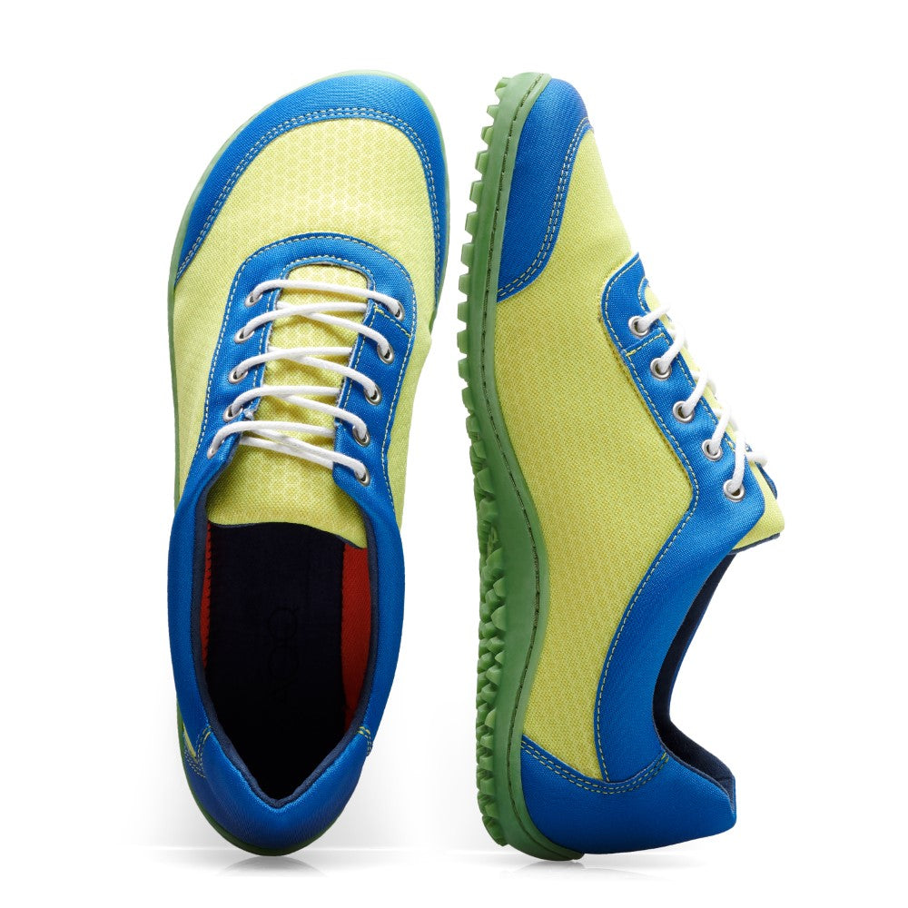 Die SQIP Lime Blue Sneaker von ZAQQ sind eine modische Wahl aus veganen Materialien und bestehen aus leuchtend gelbem Mesh-Gewebe mit blauen Akzenten. Sie sind mit weißen Schnürsenkeln und grünen Gummisohlen gestaltet. Ein Sneaker ist von oben zu sehen, während der andere von der Seite gezeigt wird, was ihr komfortorientiertes Design unterstreicht.