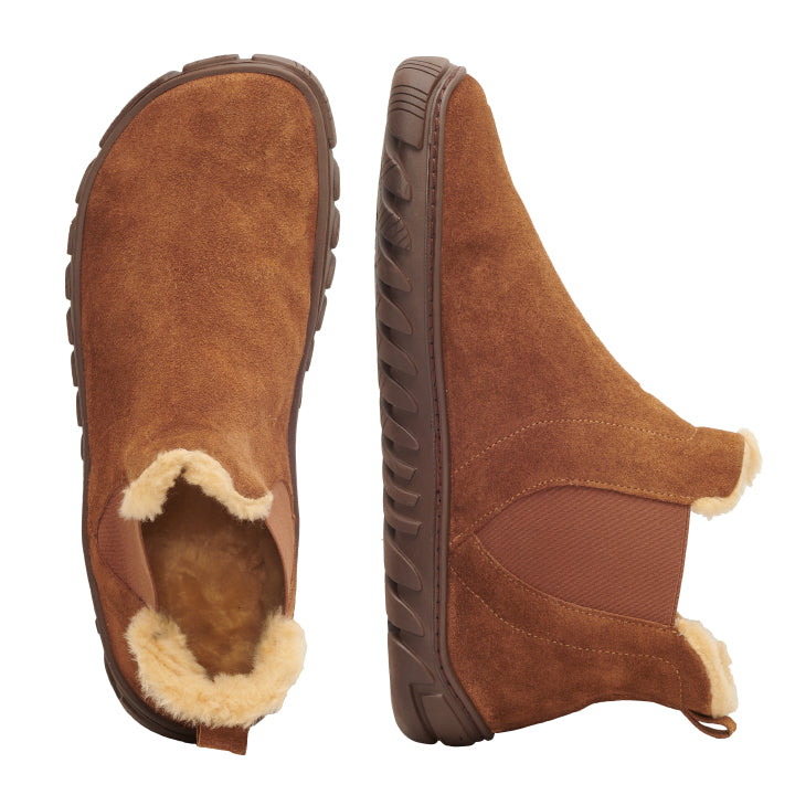 Die ZURIQ Cognac von ZAQQ sind Chelsea-Boots aus braunem Wildleder mit Kunstfellfutter und robuster Gummisohle, von der Seite und von oben zu sehen. Diese Stiefel aus Veloursleder haben elastische Einsätze für bequemes Tragen und eine Aufreißlasche an der Ferse.